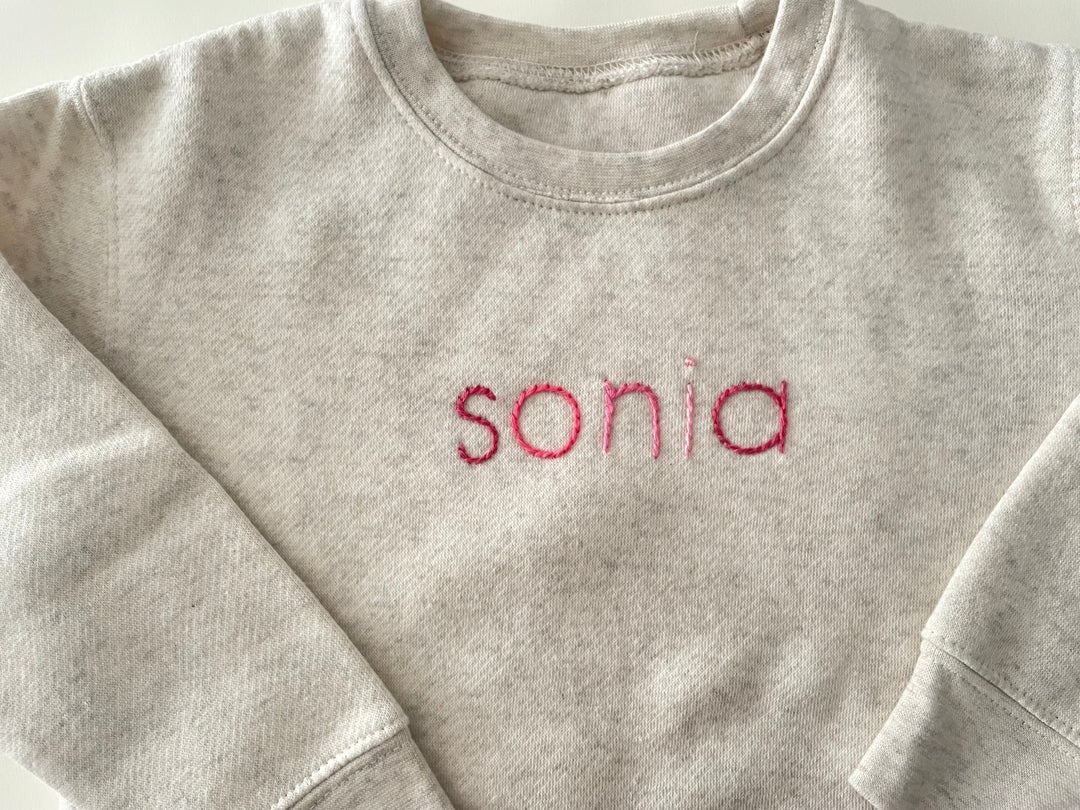 Cream Sweatshirt with custom name in alternating pink thread