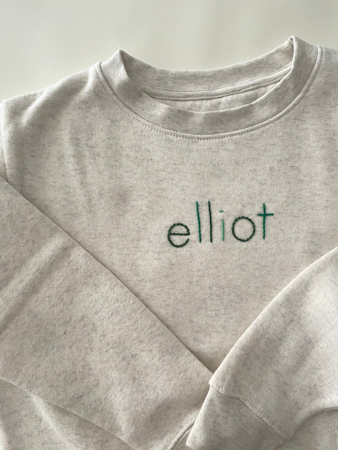 Cream Sweatshirt with custom name in alternating green thread