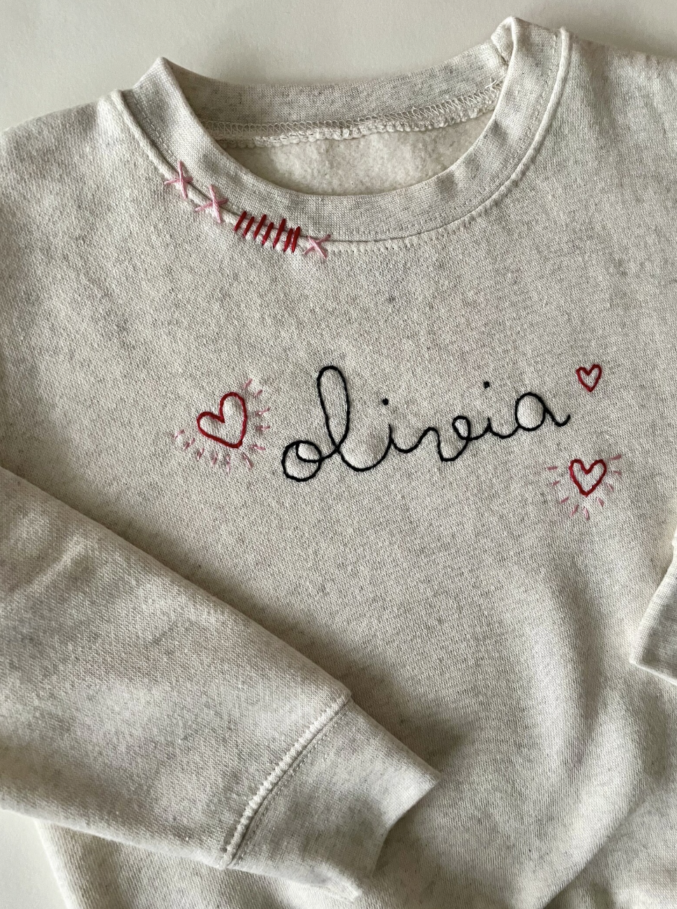 Cream sweatshirt with personalized name and hearts.  Hand embroidered.