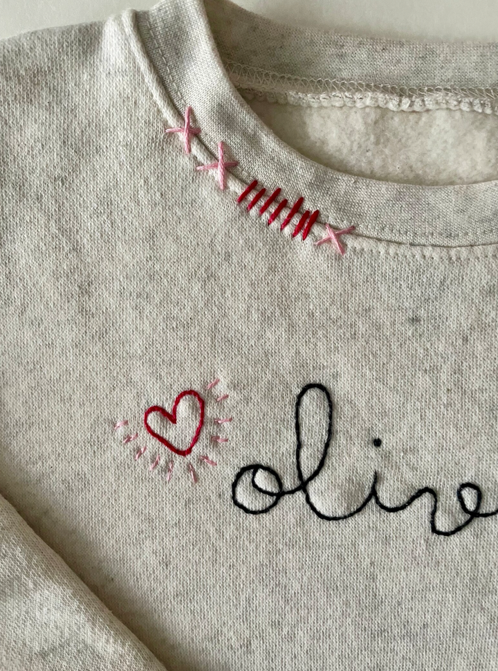 Cream sweatshirt with personalized name and hearts.  Hand embroidered.