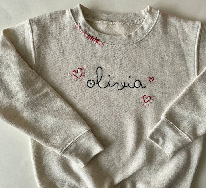 Cream sweatshirt with personalized name and hearts.  Hand embroidered.