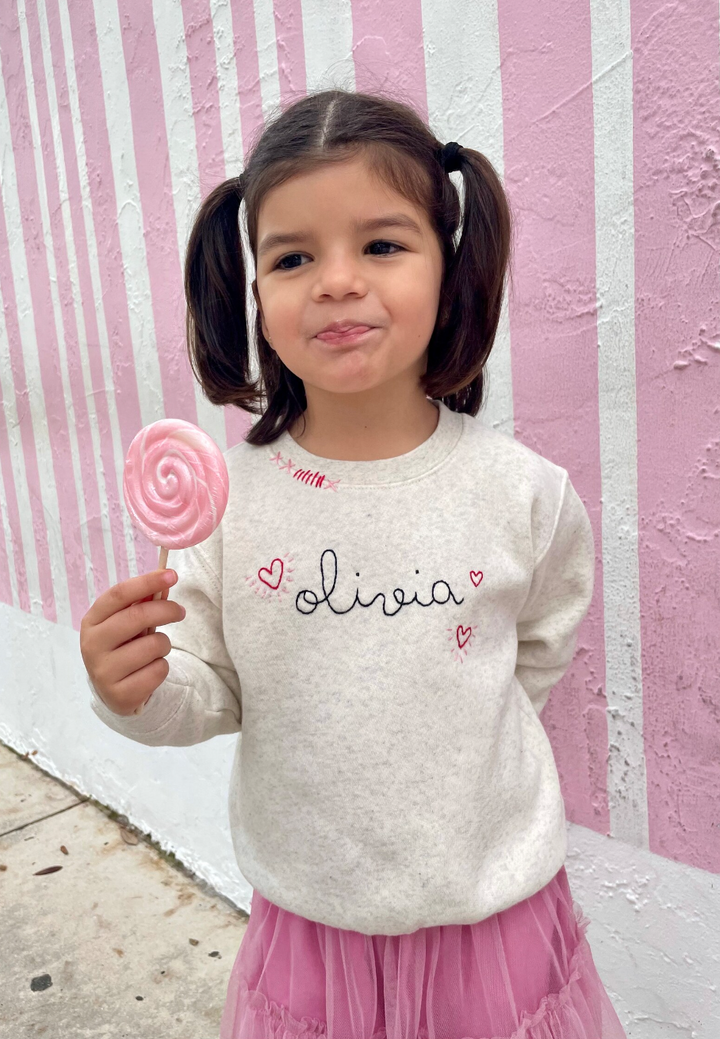 Cream sweatshirt with personalized name and hearts.  Hand embroidered.